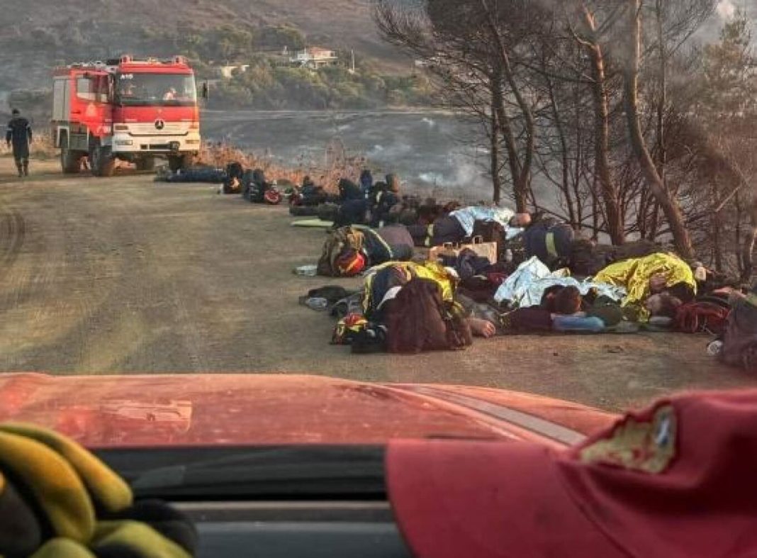 Εξαντλημένοι πυροσβέστες ξαπλωμένοι στο χώμα για να ξεκουραστούν από τη φωτιά στην Κερατέα – Η φωτογραφία που έχει γίνει viral